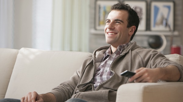man sitting on couch watching tv