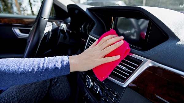 hand with rag cleaning car interior