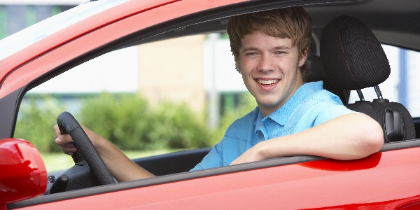 Teen driving a red car