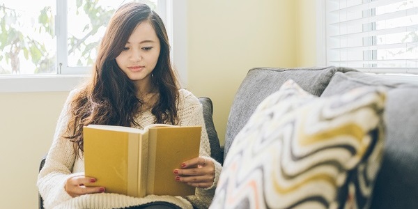 Woman reading a book on a couch