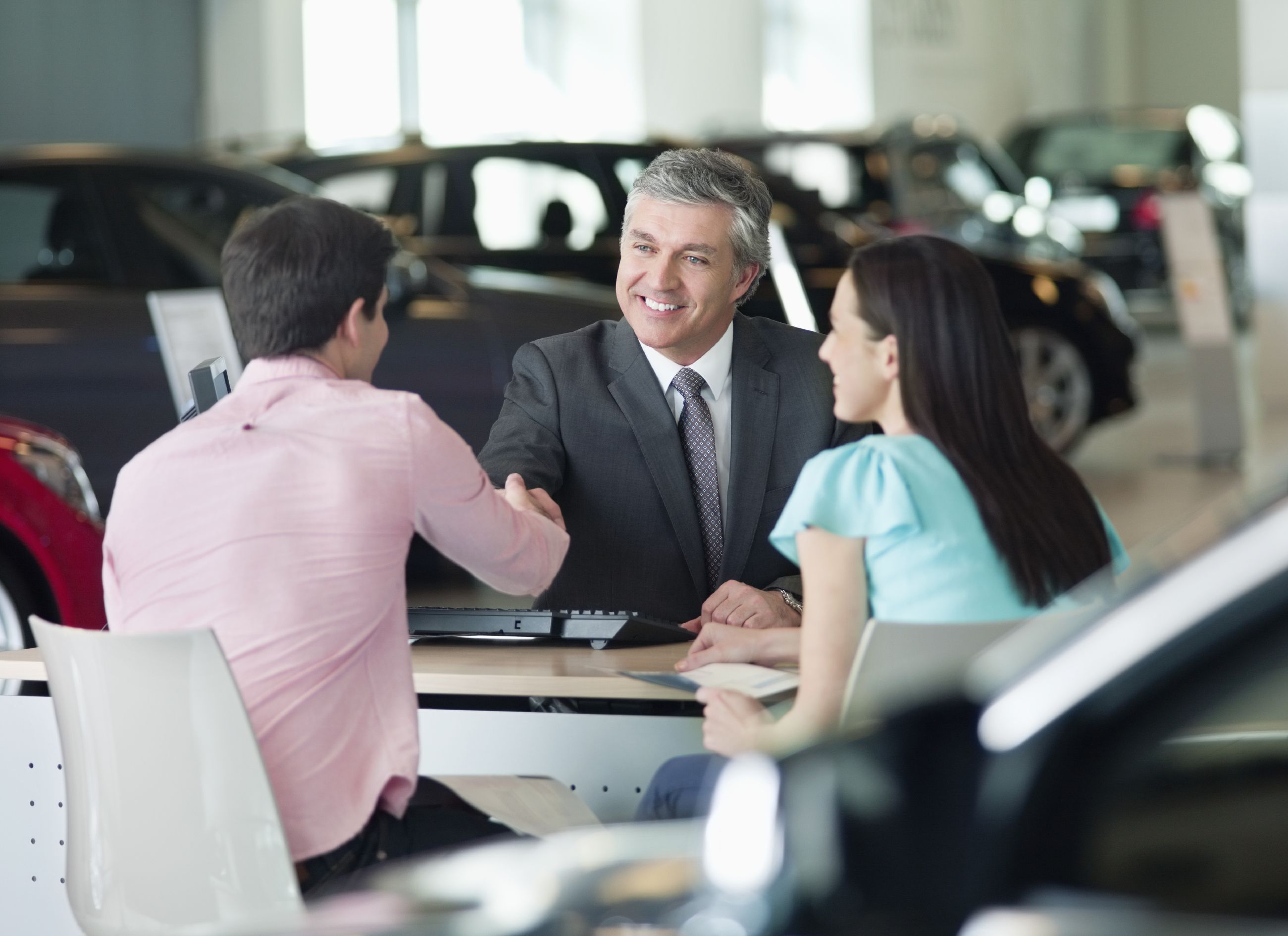Image of car salesman with man and woman